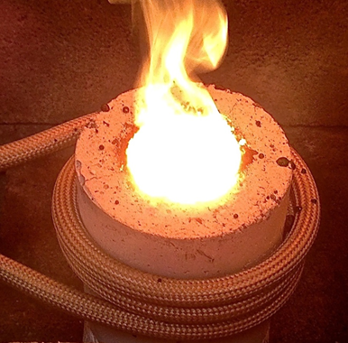 Insulated induction coil and ceramic crucible used to melt various alloys.